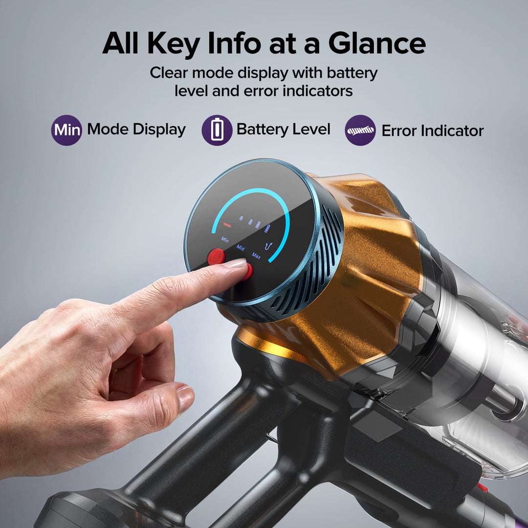 A cordless vacuum cleaner with a metallic gold and black body, featuring a clear dust bin and a circular digital display on the motor housing. A human hand is shown pressing the display button.